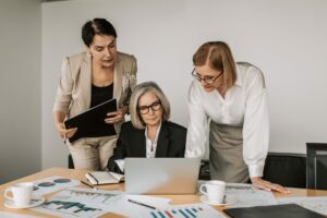 Een groep werknemers die een talent CRM op een laptop gebruikt voor het inhuren. 